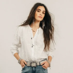 Blouse blanche brodée avec col rond fendu et fronces autour de l'encolure.
