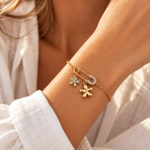 Un bracelet doré original, orné d’une épingle et de fleurs lumineuses, pour une touche féminine pleine de caractère.