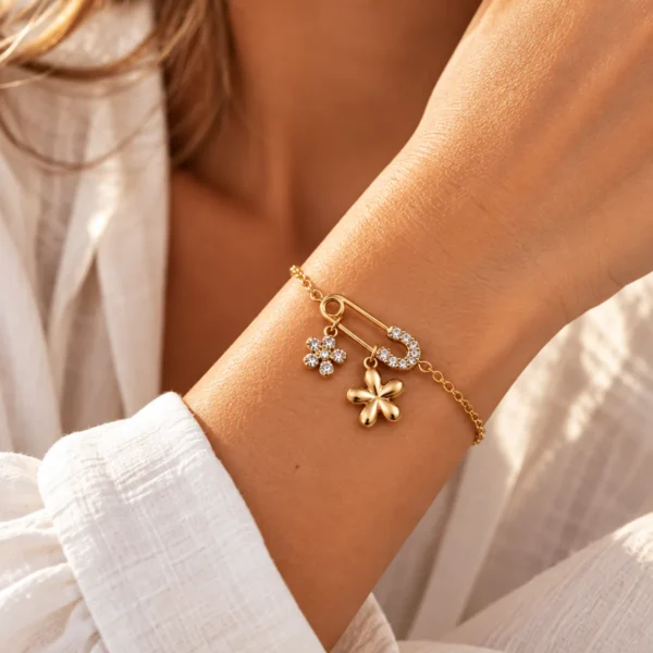 Un bracelet doré original, orné d’une épingle et de fleurs lumineuses, pour une touche féminine pleine de caractère.