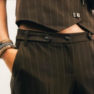 Pantalon tailleur rayé bronze coupe fluide taille haute avec rayures fines et taille haute structurée.