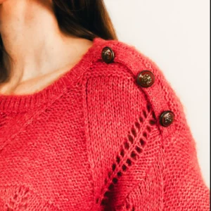 Pull grenadine ajouré boutons bijoux avec encolure ronde et emmanchures tombantes.