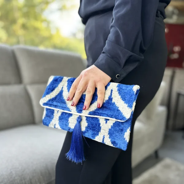 Un bleu électrique, un toucher velours et beaucoup de caractère. Cette pochette velours de soie femme séduit par son motif Ikat et son allure aussi chic qu’originale. Son pompon en soie apporte la touche finale, tandis que sa fermeture magnétique permet de garder facilement vos essentiels à portée de main. Chaque pièce possède ses propres nuances, qui font tout son charme.