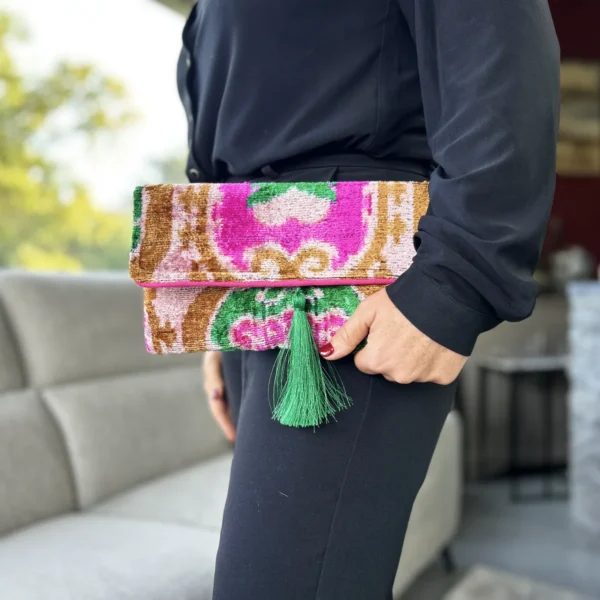 Pratique au quotidien, la pochette Ikat Marrakech accueille téléphone, clés, portefeuille et petits essentiels. Sa fermeture magnétique facilite son utilisation, tandis que son superbe pompon vert en soie apporte la touche finale. Les détails : • Velours 100 % soie • Tissage Ikat artisanal • Tons rose, vert et ocre • Pompon en soie vert • Fermeture magnétique • Dimensions : 30 × 17 cm • Nettoyage à sec • Chaque pièce est unique