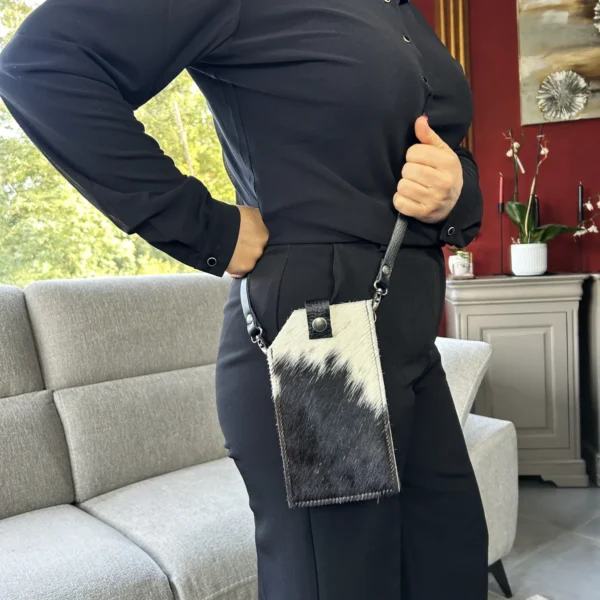 Pochette téléphone en peau de vache noir et blanc avec bandoulière en cuir