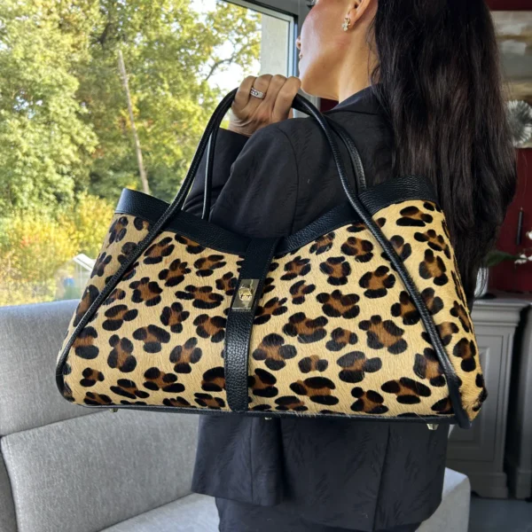 Sac léopard cuir : l'élégance italienne sauvage Un imprimé iconique, des matières d'exception et une allure irrésistible ! Le sac léopard cuir en édition limitée séduit par son association de véritable cuir Calf Hair à poils de veau et de cuir Togo noir. Son imprimé léopard apporte une touche audacieuse, tandis que ses finitions dorées soulignent son élégance.