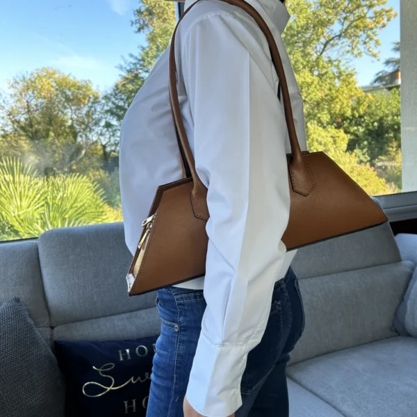 Élégant et minimaliste, ce sac trapèze camel femme séduit par sa silhouette fine et allongée. Sa teinte camel chaleureuse, son cuir de veau Box et ses détails dorés lui donnent une allure chic et intemporelle.